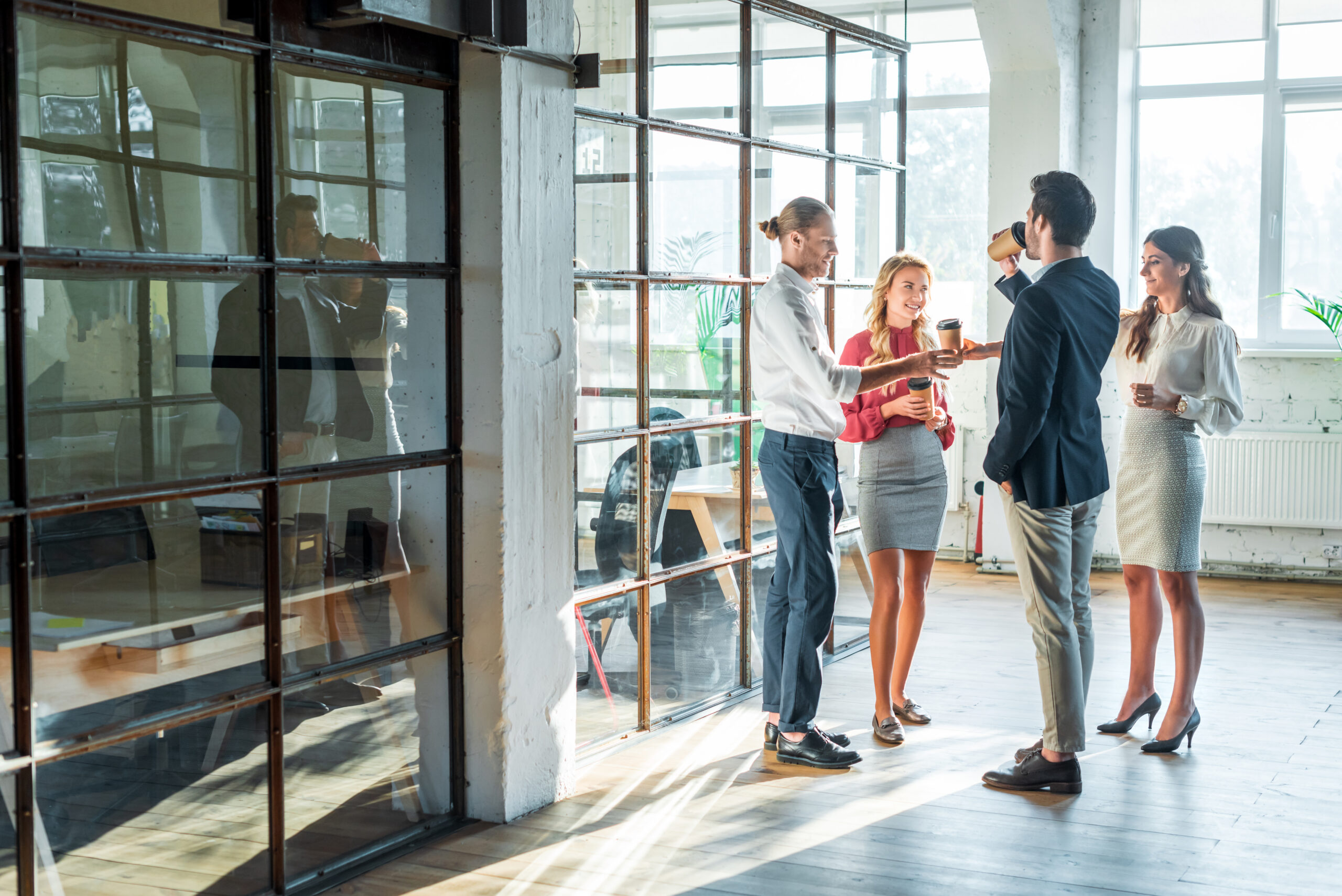 business colleagues having conversation in hall during coffee break