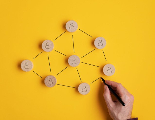 Immagine concettuale del network marketing - mano maschile che collega i cerchi di legno tagliati con l'icona di una persona.